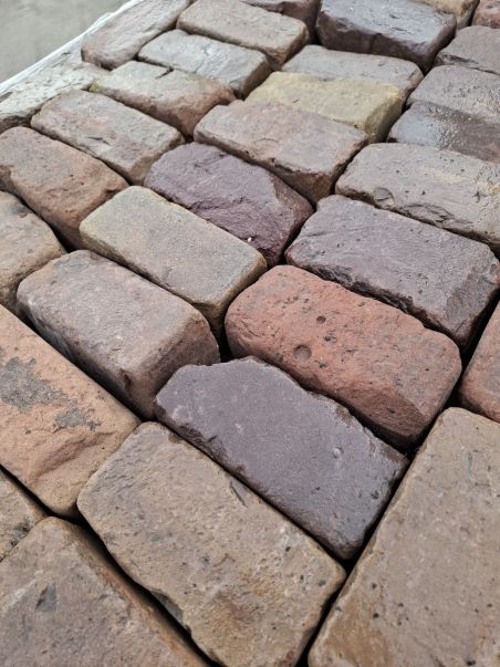 Zeer oude klinkerkeien op pallets rood genuanceerd.